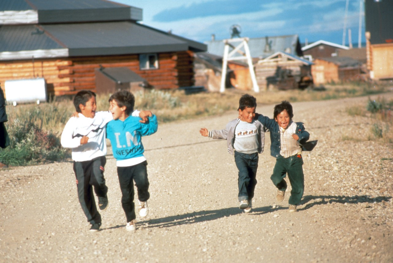Gwich’in children smiling and running on path.